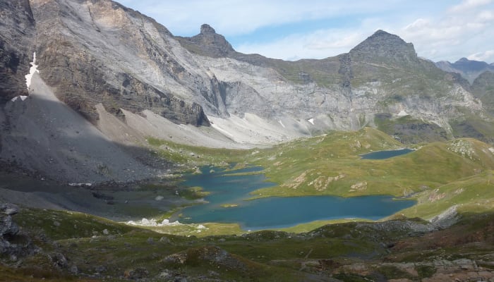 Vallée alpine avec lacs turquoise et sommets rocheux pour découverte multisport en montagne