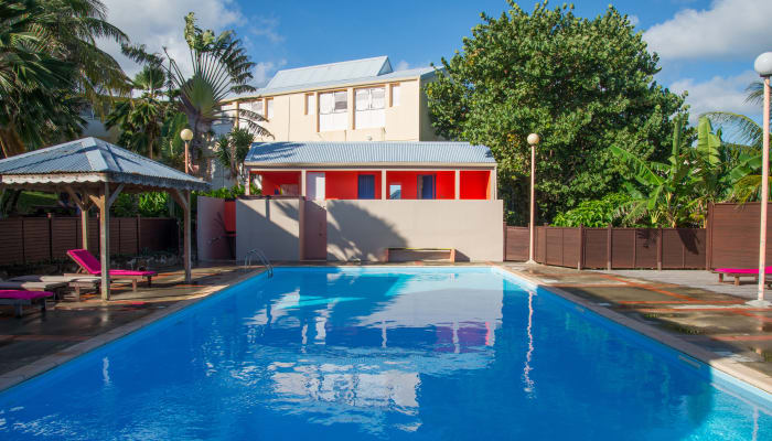 Village sportif du Vauclin avec piscine olympique, bâtiments d'activités et palmiers en Martinique pour séjour jeunes