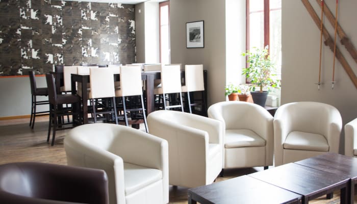 Centre UCPA Chamonix avec espace détente aux fauteuils blancs, zone de restauration et skis muraux décorés