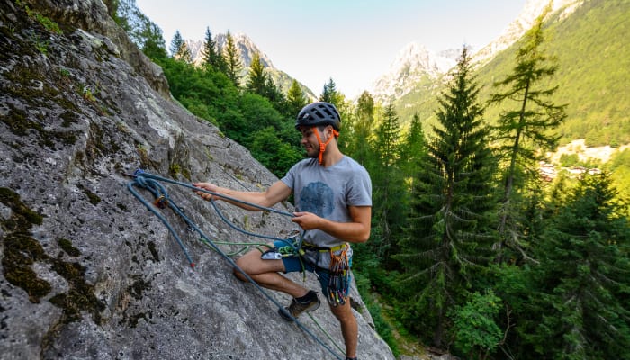 Grimpeur en escalade sur paroi rocheuse alpine avec équipement de sécurité dans les glaciers du Mont-Blanc