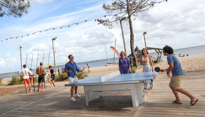 Groupe pratiquant le tennis de table et beach volley sur la plage du domaine de Bombannes en Gironde
