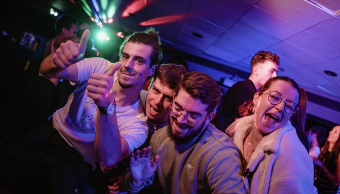 Groupe de jeunes adultes s'amusant ensemble lors d'une soirée Fresh Fresh Week, ambiance festive avec lumières colorées
