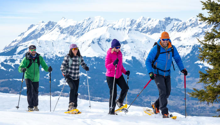 Groupe de randonneurs en raquettes à neige en Italie avec montagnes enneigées et paysage alpin en arrière-plan