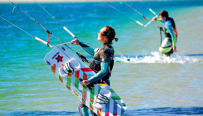 Monitrice de kite en mer tenant sa voile colorée lors d'une formation de détection UCPA internationale
