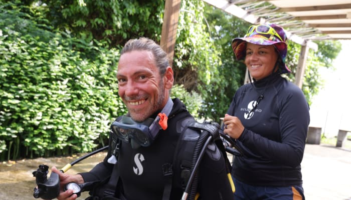 Plongeur en équipement de plongée profonde souriants avec moniteur avant exploration sous-marine aux Caraïbes