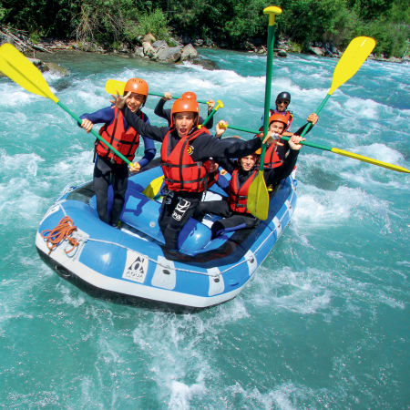 Enfants en tenue de rafting sur rivière turquoise des Pyrénées avec pagaies jaunes et gilets de sauvetage orange