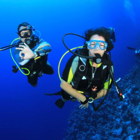 Plongeurs en équipement de plongée explorant les fonds marins en Corse lors d'un séjour multisports