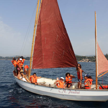 Enfants en gilets de sauvetage orange naviguant sur un voilier traditionnel dans le Golfe du Morbihan lors d'un séjour nature