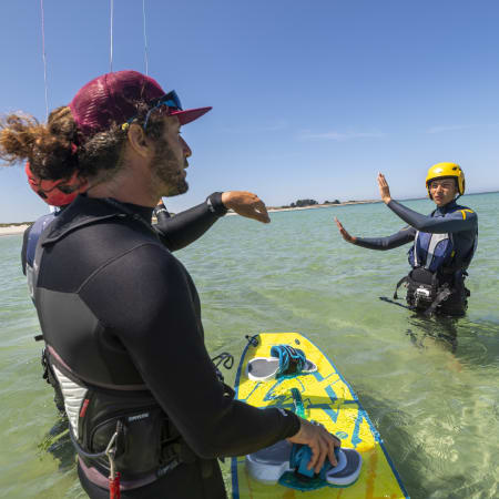 Moniteur de kitesurf enseignant à un élève en mer avec planche et équipement de sécurité à Bénodet