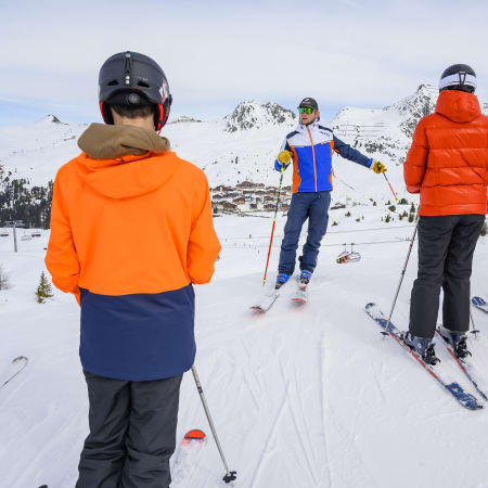 Groupe de jeunes skieurs en formation avec moniteur dans les Alpes, apprentissage du ski hors-piste en poudreuse