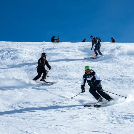 Adolescents skiant et snowboardant sur les pentes enneigées des Arcs lors d'un séjour d'initiation à expert