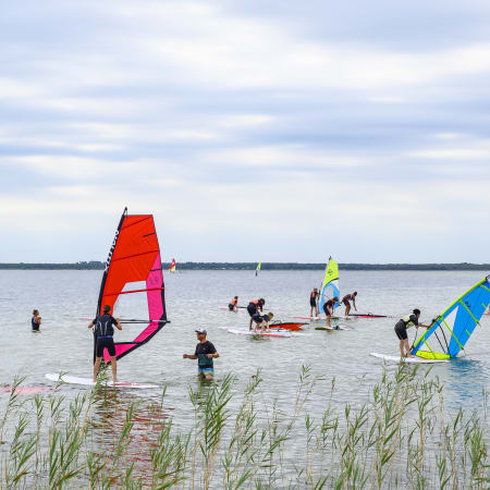 Groupe de jeunes pratiquant le windsurf et sports nautiques à Bombannes, séjour multisports 14 jours