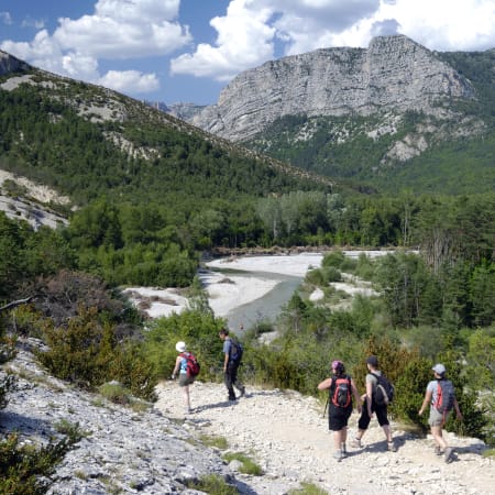 Groupe de randonneurs sur un sentier du canyon du Verdon avec falaises calcaires et rivière turquoise