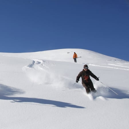 Skieurs experts en descente hors-piste à la Vallée Blanche sur pentes enneigées avec ciel bleu