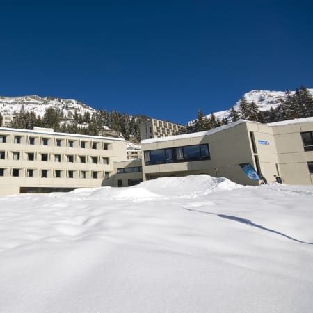 Centre UCPA de Flaine Altaïr en montagne avec bâtiments modernes entourés de neige et sommets alpins enneigés