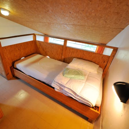 Chambre double avec lit en bois et fenêtres au centre UCPA Bombannes