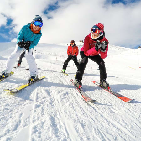 Moniteur UCPA enseignant le ski à deux skieurs sur les pistes enneigées de La Plagne en montagne