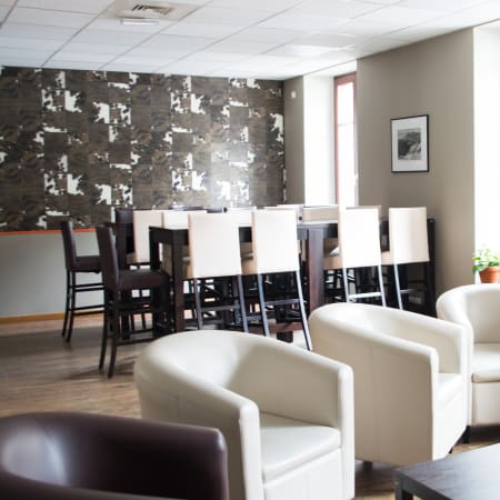 Centre UCPA Chamonix avec espace détente aux fauteuils blancs, zone de restauration et skis muraux décorés