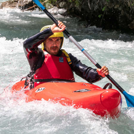 Participant au rafting découverte Happy Summer naviguant en kayak sur les eaux vives turquoise avec équipement de sécurité complet