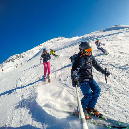 Groupe de skieurs en coaching sur les pentes enneigées de Chamonix par beau temps
