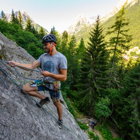 Grimpeur en escalade sur paroi rocheuse alpine avec équipement de sécurité dans les glaciers du Mont-Blanc