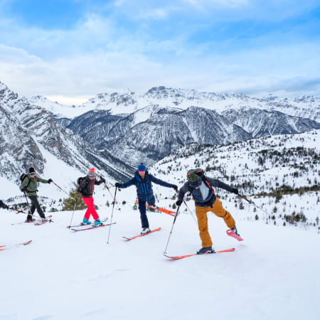 Groupe de randonneurs à ski dans les Pyrénées enneigées avec moniteur, vallée d'Aure en arrière-plan