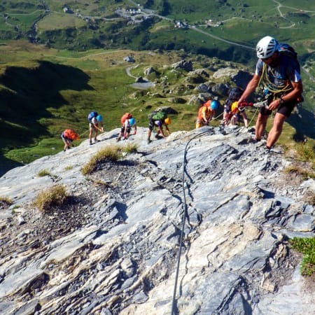 Groupe de randonneurs équipés en escalade sur paroi rocheuse en montagne lors d'un séjour multisports Audace