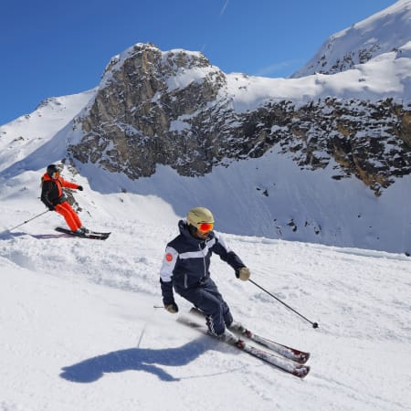 Jeunes skieurs en cours de ski aux Arcs avec pistes enneigées et sommets montagneux