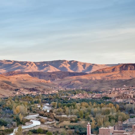 Vallée du Drâa avec djebels ocre, rivière sinueuse et oasis verdoyante dans le grand sud marocain