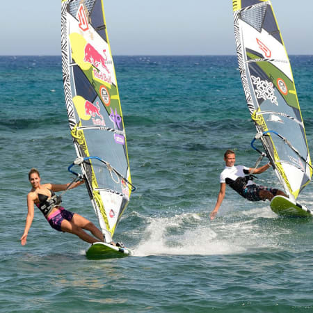 Deux windsurfeurs progressant sur les vagues du Lagon de Sotavento avec voiles colorées et planches de windsurf