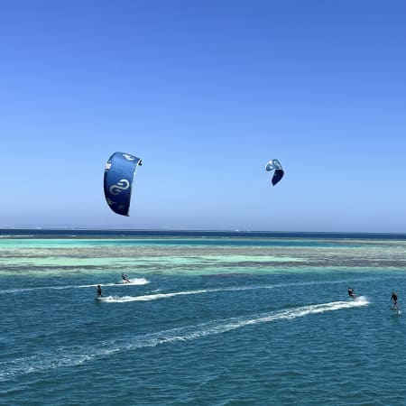 Kitesurfeurs en action sur eau turquoise avec cerfs-volants colorés, croisière débutant à Hurghada