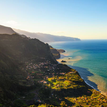 Falaises côtières verdoyantes des Balcons de l'Atlantique surplombant l'océan bleu avec villages et plages en contrebas