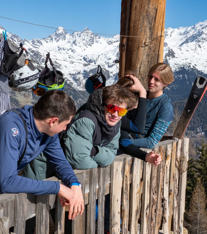 Groupe d'adolescents débutants en ski aux Arcs avec vue sur les sommets enneigés des Alpes en arrière-plan