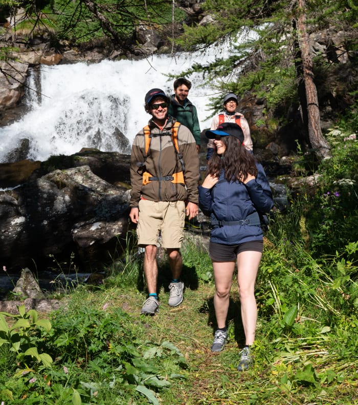 Groupe de randonneurs en montagne près d'une cascade dans la vallée de Serre Chevalier aux Hautes Alpes
