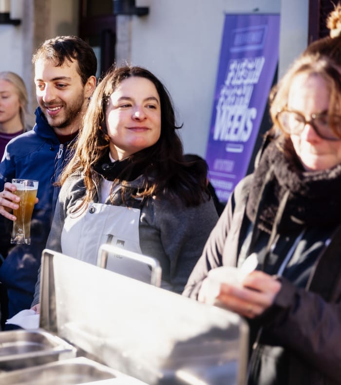 Groupe de jeunes skieurs riant et discutant lors d'une soirée conviviale à Chamonix avec verres à la main