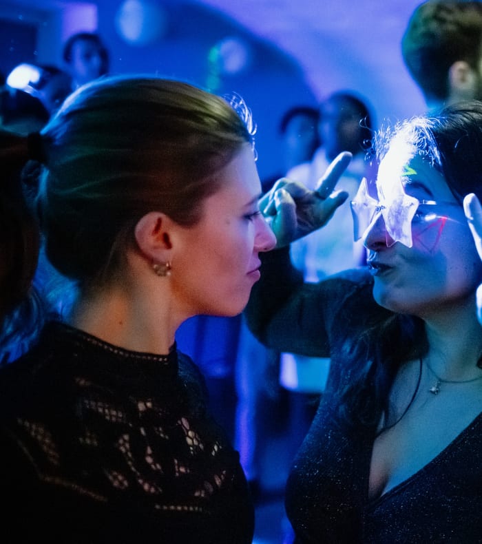 Groupe de jeunes adultes célébrant avec bracelets luminescents et ambiance festive en soirée