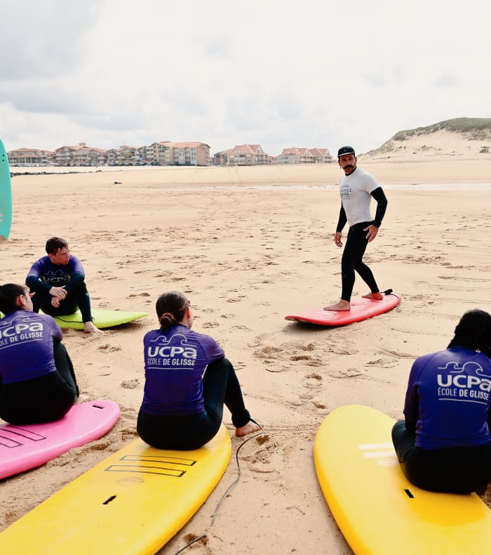 Groupe de jeunes surfeurs en cours de surf sur la plage de Soustons avec planches colorées et instructeur