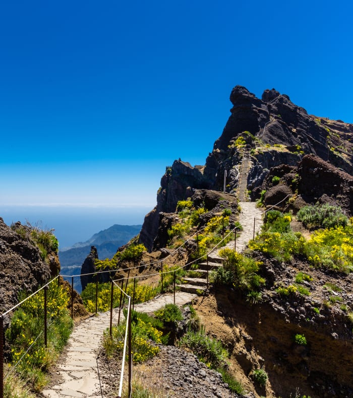 Sentier de randonnée montagneux à Madère avec vue panoramique sur l'océan Atlantique et Porto Santo à l'horizon