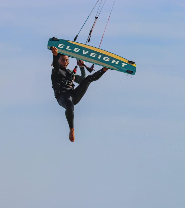 Kitesurfeur en action avec cerf-volant Liberté bleu et jaune au-dessus de l'océan à Essaouira