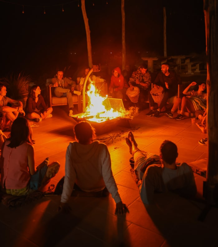 Groupe de voyageurs réunis autour d'un feu de camp lors d'une découverte culturelle au Maroc