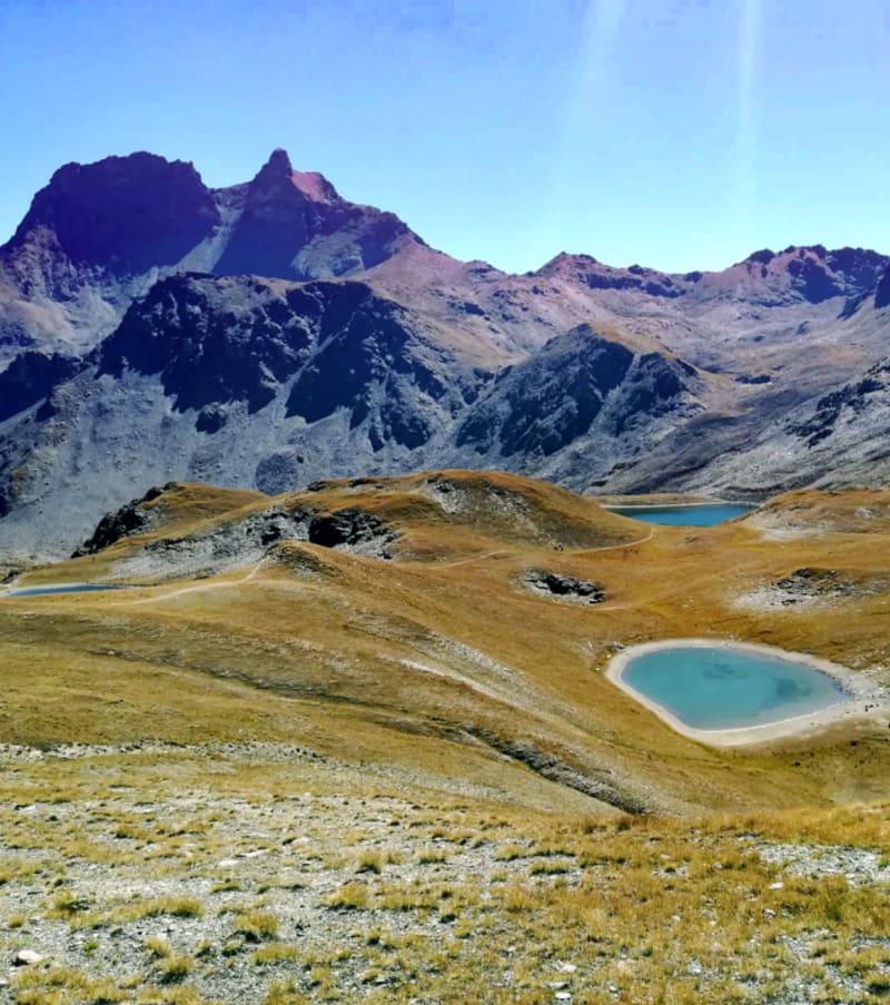 Vallée alpine de Valgrisenche avec pics rocheux, lacs turquoise et prairies dorées, trek en montagne Val d'Aoste