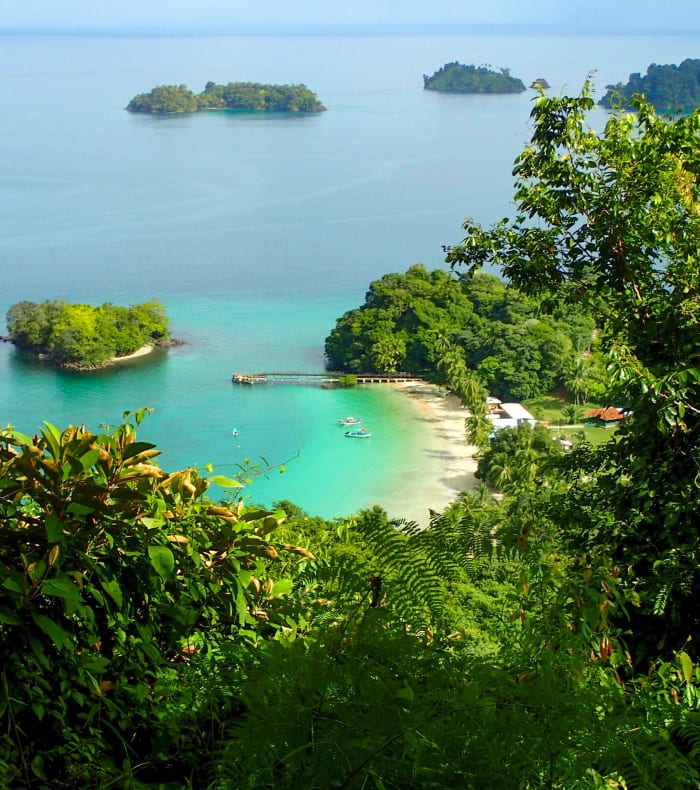 Baie tropicale de Panama avec eaux turquoise, îles verdoyantes et plage de sable blanc bordée de végétation luxuriante