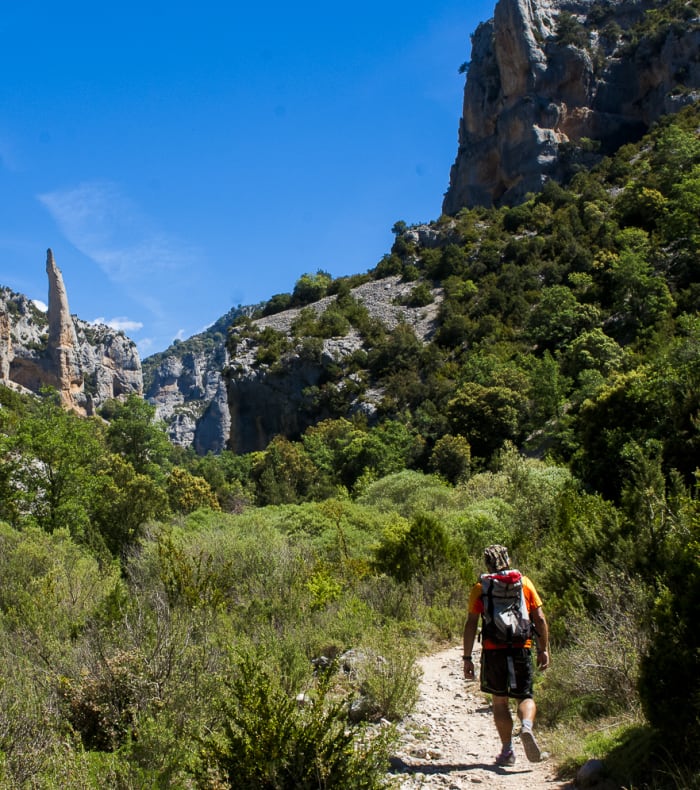 Randonnée dans les canyons de la Sierra de Guara avec falaises rocheuses et végétation méditerranéenne sous ciel bleu