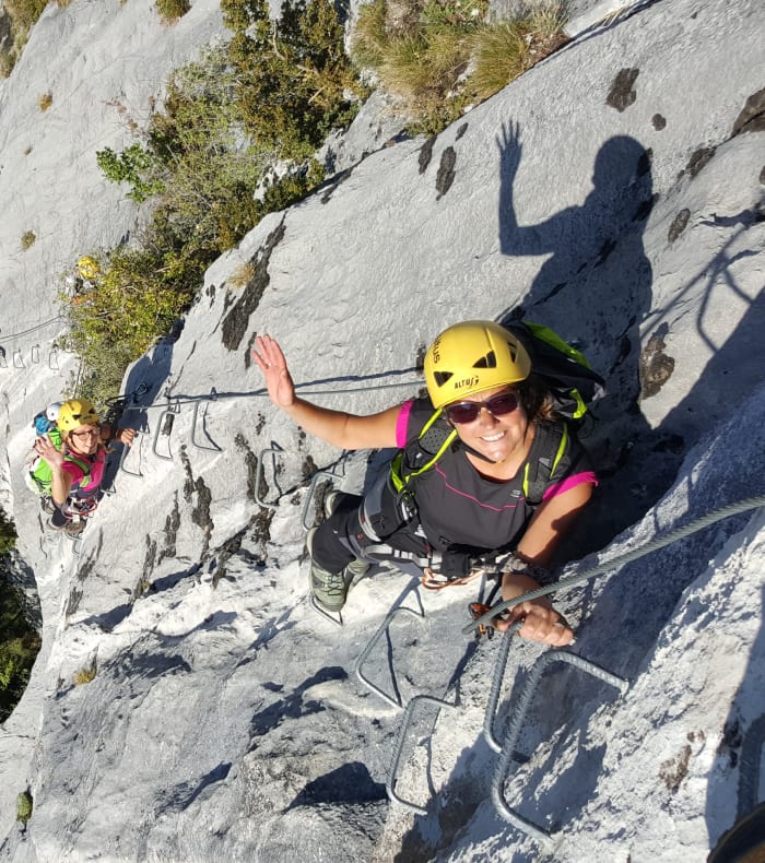 Grimpeur en via ferrata sur falaise calcaire de la Sierra de Guara avec équipement de sécurité et vue aérienne du canyon