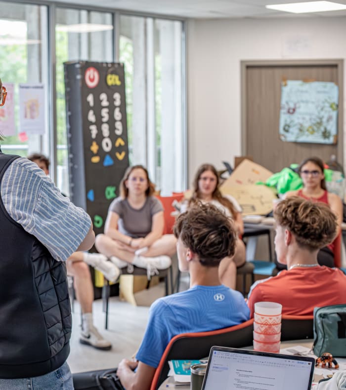 Formateur UCPA animant une session de formation BAFA en internat avec groupe de stagiaires en salle de cours