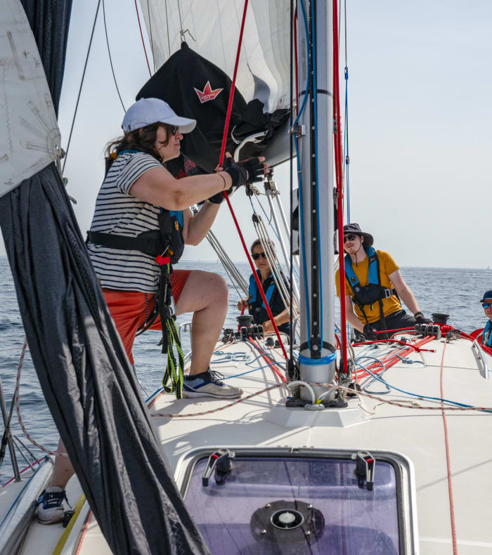 Stagiaires en formation manœuvrant les voiles d'un voilier de croisière en Bretagne lors du stage CQP