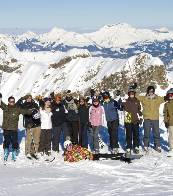 Groupe de skieurs et snowboardeurs posant ensemble sur les pistes enneigées de Flaine avec vue panoramique sur les Alpes