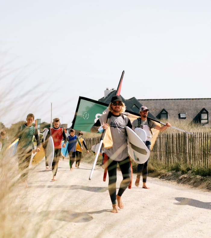 Famille profitant de la plage à Vieux-Boucau avec dunes herbeuses et maisons côtières en arrière-plan