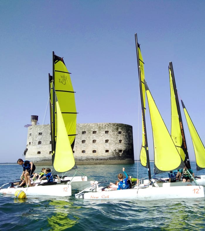 Catamarans avec voiles jaunes face au Fort Boyard lors d'une classe de mer sports nautiques à Oléron