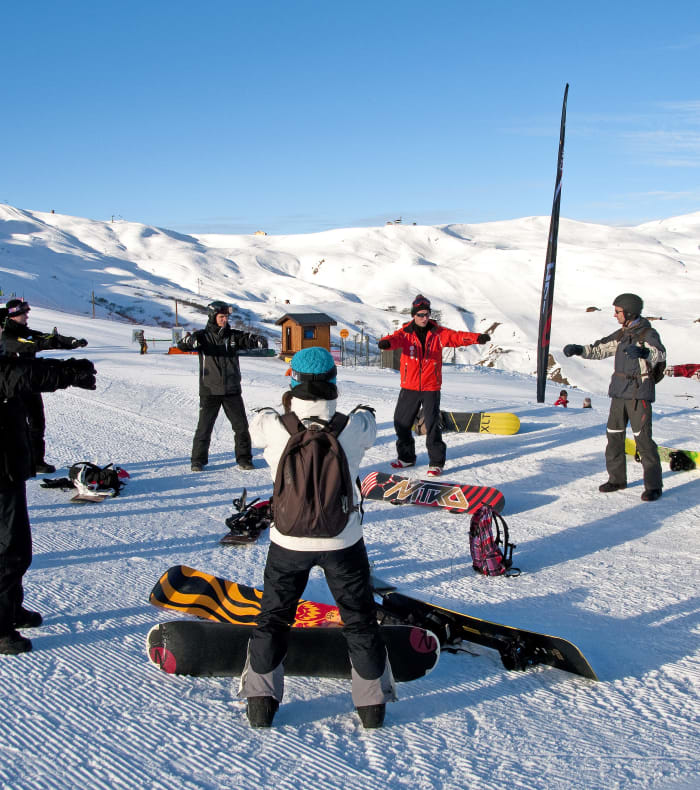 Groupe de skieurs en tenue colorée sur les pistes enneigées de la Plagne par beau temps